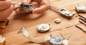 Horloger réparant le mouvement d'une montre mécanique sur son établi
